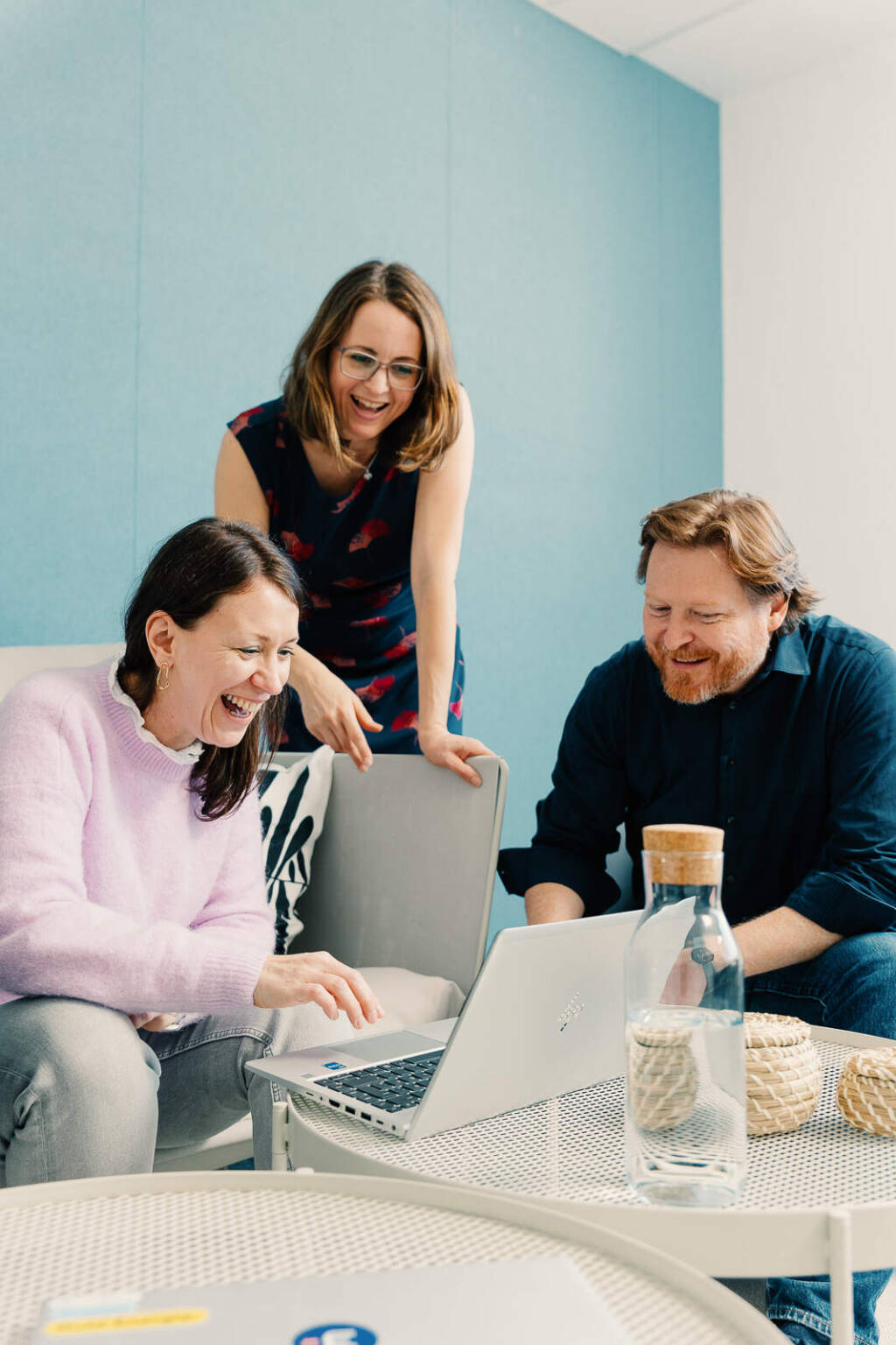Businessfotografie in Karlsruhe: Gruppe arbeitet gemeinsam am Laptop, lacht u zum Thema Businessfotografie Karlsruhe - Gruppe am in Arbeiten