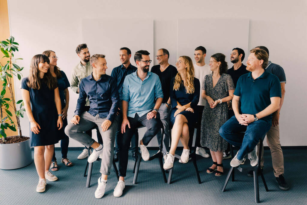 Businessfotografie Karlsruhe: Teamfoto eines Unternehmens im Büro, Mitarbeitende sitzen zum Thema Businessfotografie Karlsruhe - in Teamfoto